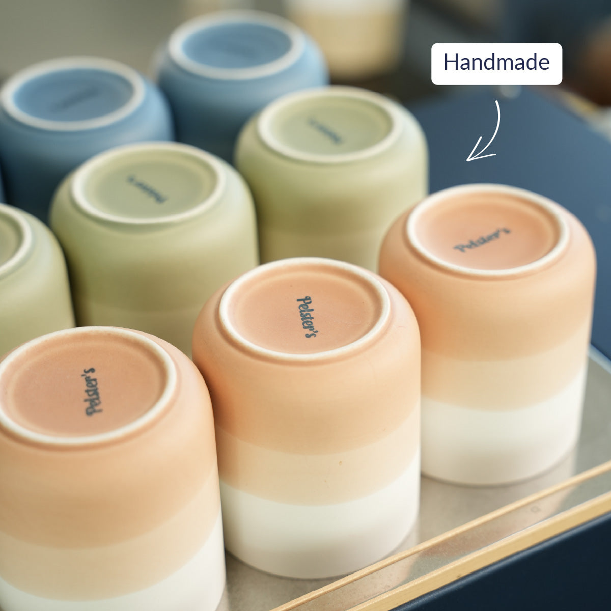 Porzellan Becher in verschiedenen Farben mit Pelsters Logo mit handmade USP