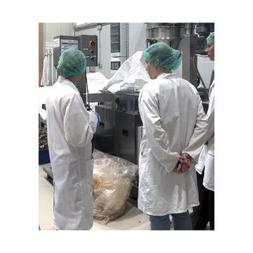 Menschen im Kittel  in einem Produktionsraum 